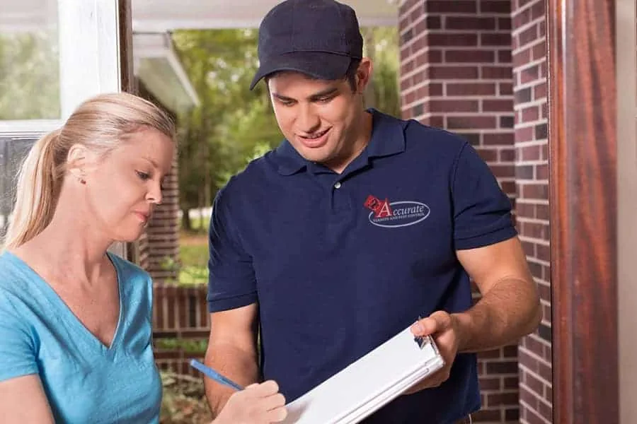 An Accurate Termite and Pest Control technician going over a treatment plan with a homeowner